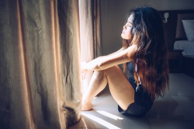 Yerde oturan genç bir kadının portresi Panik ya da Depresyon hastalığının zihnine saldırması.