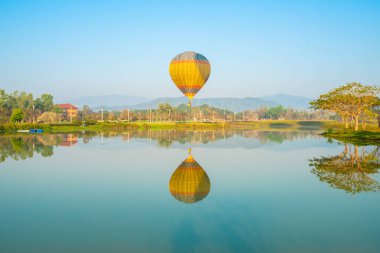 Singha Parkı 'ndaki gölde sıcak hava balonlarının yansıması, Chiang Rai. Balonculuk dünyanın en iyi ve en sıradışı aktivitelerinden biridir. Kimsenin kaçırmaması gereken..