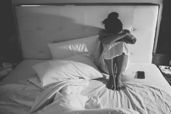 ベッドルーム 黒と白のトーンでベッドの上に一人で座って落ち込んで女性の肖像画 壊れた心の悪い状態の概念 悲しみ 孤独や憂うつな女性 — ストック写真