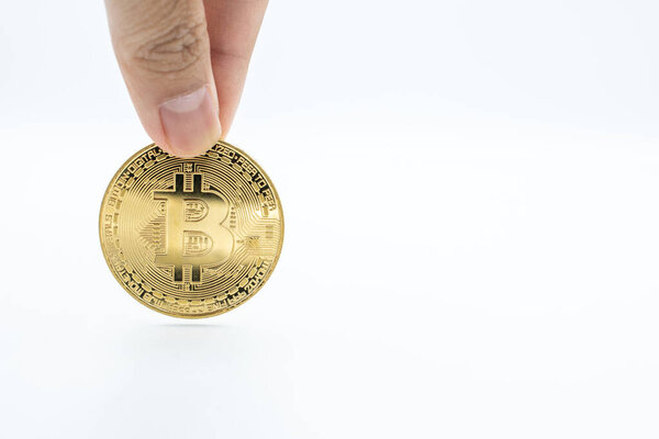 Кто-то с золотым биткойном на белом фоне. Bitcoin является одним из популярных криптовалют (цифровые активы), это инновационная платежная сеть и новый вид денег