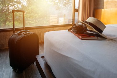 Bavul, şapka, kamera gibi seyahat aksesuarları. rahat bir otel odasında rahat bir şekilde. Tatil / tatil zamanı kavramı.