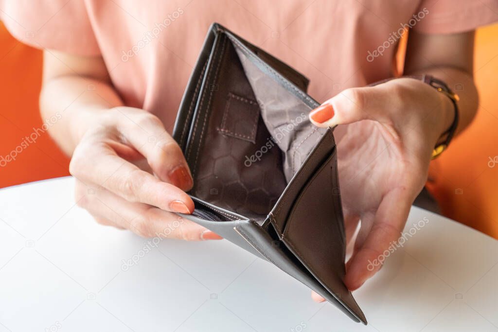 Close-up of woman hands open an empty wallet, Bad economics situation. Conceptual of unhappy bankrupt woman.
