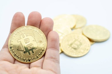 Beyaz arka planda izole edilmiş altın Bitcoin 'i tutan birinin yakın çekimi. Bitcoin popüler bir kripto para birimi, yeni bir tür para..