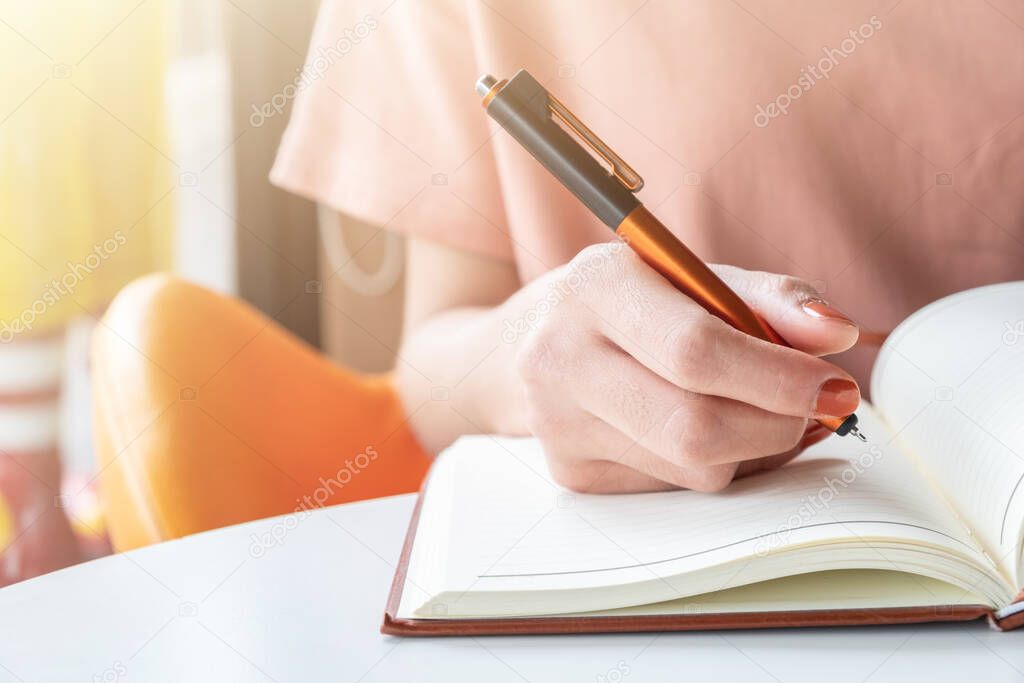 Close up of female hand with pen preparation to writing somethings in notebook. Conceptual of Education or Writer on working.