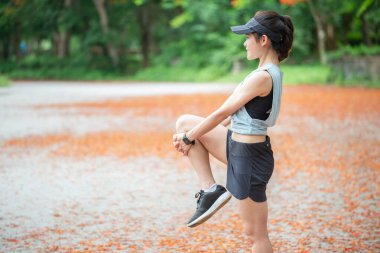 Koşucu kadın portresi koşmadan önce esneme ve ısınma hareketleri yapıyor. Esneme hareketi esnekliği artırabilir ve yaralanma riskini azaltabilir..