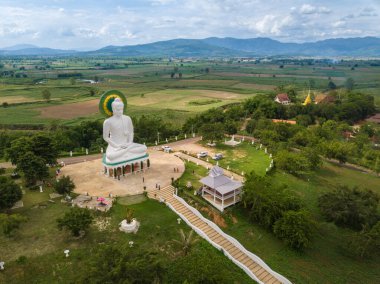 Tayland 'ın Chiang Rai eyaletinin kuzeyindeki Chiang Saen ilçesine bağlı Wiang Kaew köyündeki küçük bir tepenin üzerindeki beyaz Buda' nın hava manzarası..