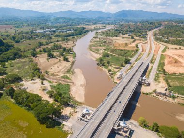 Tayland 'ın Chiang Rai ilinin Doi Hang ilçesindeki Kok Nehri' ni geçmek için inşa edilen yeni köprünün güzel hava manzarası. İnsansız hava aracından doğanın güzel manzarası.  