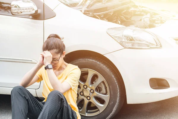 Genç stresli bir kadın yolda araba arızası yaşıyor ve birinin ona yardım etmesini bekliyor. Yoldaki araba kazası kavramı.