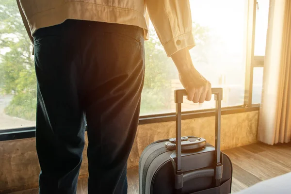 Otel odasında bavulunu tutan turist kadının görüntüsü. Seyahat ve tatil kavramı.