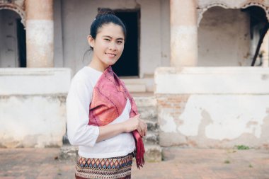 Laos 'un kuzey merkezindeki UNESCO dünya mirası alanı Luang Prabang' daki eski tapınağın önünde geleneksel giysiler giyen Asyalı kadının portresi..
