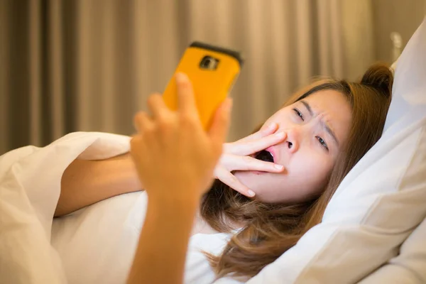 Сонная Женщина Лежит Кровати Зевает Использует Смартфон Поздно Ночью Концепция — стоковое фото