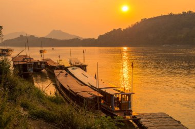 Luang Prabang, Laos 'taki Mekong nehri üzerinde güzel bir gün batımı manzaralı yerel tekne. Mekong Nehri, Güneydoğu Asya 'nın en uzun nehri, Asya' nın en uzun 7. nehri..