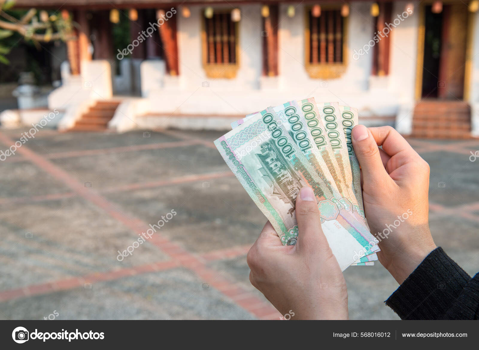 持有老挝基普钞票10万基普老挝国家货币的人被剪下来的照片——图库图片© Boysloso #568016012