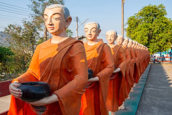 Tachileik 'teki Budist manastırında sıra sıra duran Budist keşiş heykeli, Tayland' ın Chiang Rai eyaletinin Mae Sai ilçesine yakın bir sınır kasabası..