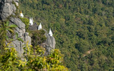 Tayland 'ın Lampang eyaletinin en turistik yerlerinden biri olan Wat Chaloem Phra Kiat tapınağındaki dağın yamacında yüzen bir grup pagoda..