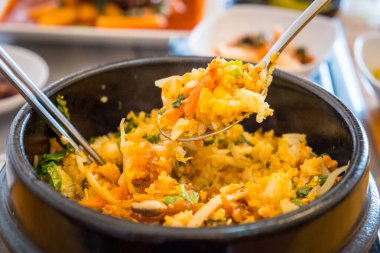 Bibimbap 'a yakın, geleneksel Kore yemekleri sıcak kâsede servis edilir ve karışık pirinç ile sebze, yumurta ve et ile pişirilir. Kore yemeklerinin en popüler yemeklerinden biri..