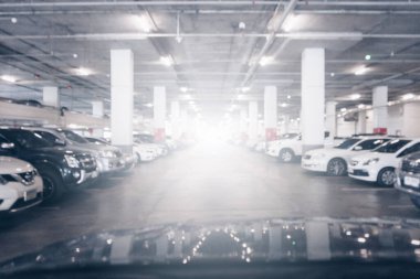 Blurred image of cars parking lot in underground car parks in the shopping mall. Blurred background concept.