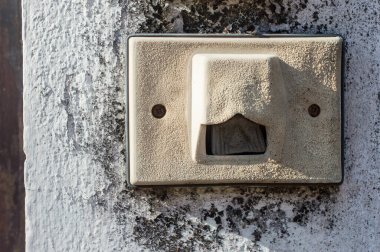 The antique bell switch at the front doll. A doorbell is a signaling device typically placed near a door to a building's entrance.