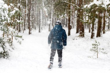 Kış ormanlarında kar fırtınasında çocuk görüntüsünü yok et. Aktif olarak dışarıda zaman geçirmek. Kış karlı ormanlık. Kar fırtınasında soğuk soğuk hava. Mutlu bir çocukluk. Odaklanamıyorum.