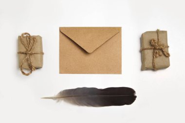 Kahverengi eko zarf beyaz arka planda. Beyaz arka planda küçük bir Noel hediyesi. Noel tatili kavramı. Noel Baba 'ya mektup. İp yayı. Tüy kalem..