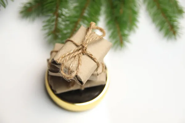 白い背景に丸い金の鏡の上に立つ工芸品の小さな贈り物のトップビュースタック ロープ クリスマス休暇のコンセプト 願い事リスト レトロでアンティークでヴィンテージ 天然緑のモミの枝 — ストック写真