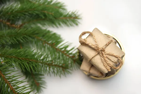 白い背景に丸い金の鏡の上に立つ工芸品の小さな贈り物のトップビュースタック ロープ クリスマス休暇のコンセプト 願い事リスト レトロでアンティークでヴィンテージ 天然の緑のモミの枝 エコボックス — ストック写真
