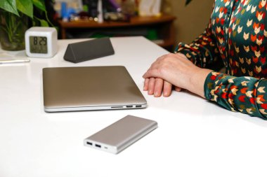 Evde bilgisayarla çalışan kollarını kavuşturmuş tanınmayan bir kadın. Bir iş günü başlar ya da biter. Çalışma masasında oturan ve bilgisayarını kapatan genç bir kadın. İş yeri. Kadın eli..