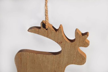 Beyaz arka planda izole edilmiş Noel geyiği oyuncağı. Beyaz arka planda küçük tahta model bir geyik oyuncağı. Noel geyiği asılıyor. Tebrik kartı. Uzayı kopyala Kış tatili konsepti. Model.