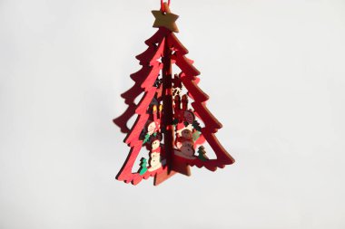 Noel ağacı oyuncağı. Beyaz arka planda izole edilmiş ahşap küçük model çam ağacı kıvrak zekalı sarı yıldız. Noel ağacı sallanıyor. Kutlama kartı. Uzayı kopyala Karanlık gölge.