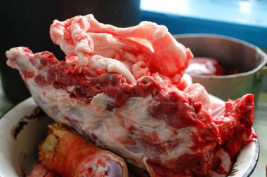 Chopped pork bones in aluminum plate. Pork meat concept close-up. Pig's head chopped off. No people. Farmer concept. Animal abuse. Pork meat. Farmer produce. Side view. Close-up. Entrails, liver.