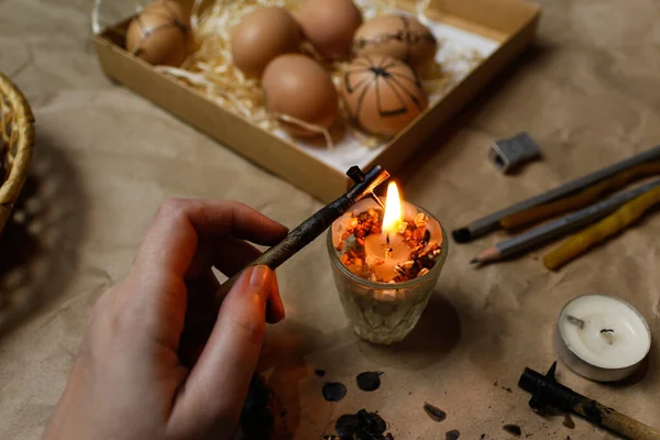 Dişi el kalem, pysachok, ateşin yanında ve ısıtıyor. Folk tasarımlarıyla süslenmiş Ukrayna Paskalya yumurtalarını boyamaya hazırlanıyorlar. Pysanka, Paskalya yumurtası.