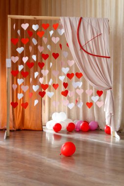 Valentines Day background with paper hearts. The red and white heart shapes on wooden arch background in love concept for 14 February. Love concept. Air balloons.