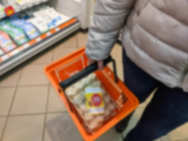 Defokussieren Weibliche Hand Hält Supermarkt Korb Verschwommenen Hintergrund Mit Verschiedenen — Stockfoto