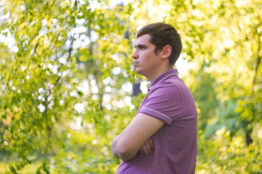 Defocus hoş, neşeli, yakışıklı genç adam. Profil görünümü. Doğa yeşili arka plan. Farkındalık kavramı. Akıl sağlığı. Psikoloji ve psikoterapi. Odaklanamıyorum.