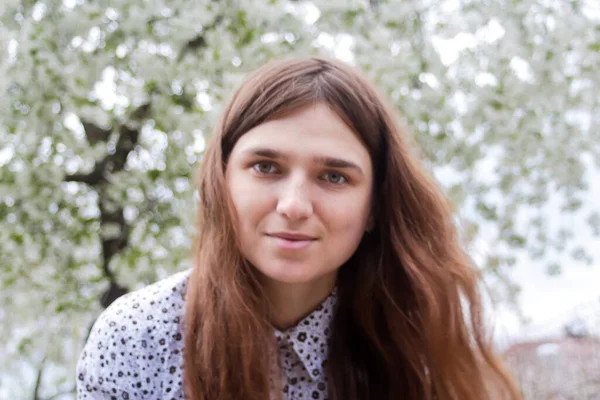 Çiçek açan ağaçların etrafındaki romantik aroma parkında açık havada çekilmiş uzun saçlı beyaz kadın portresi. Romantik bir portre. Odaklanamıyorum.