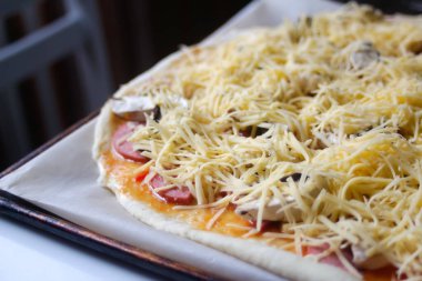 Defocus, taze rendelenmiş mozzarella peynirli tüm pizzayı yakından çek. Defocus hamur üzerinde pizza malzemelerini bulanıklaştırdı. Uzayı kopyala İtalyan mutfağı geçmişi. Arkaplan. Taze Margarita odak dışı.