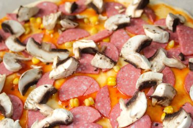 Hamur üzerinde pizza için Defocus yakın çekim malzemeleri. Kırmızı domates sosu, sosis, tatlı mısır. Ev yapımı İtalyan pizzası. Ev mutfağı. Üst Manzara. İtalyan mutfağı geçmişi. Odaklanamıyorum.