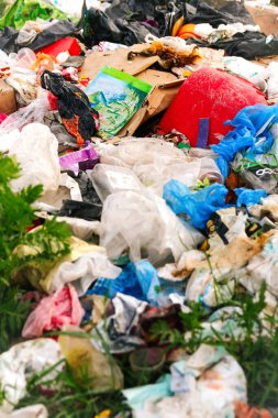 Defocus huge landfill of garbage. Concept of ecology. Large garbage pile on nature green grass background, global warming. Closeup. Pollution vertical. Out of focus.