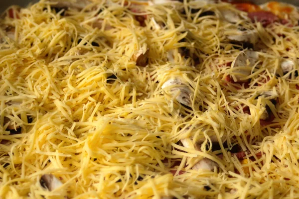 Defocus, üzerine taze rendelenmiş mozzarella peyniriyle tüm pizzayı yakın plan çek. Hamur üzerinde pizza için Defocus yakın çekim malzemeleri. Ev yapımı sarı İtalyan pizzası. İtalyan mutfağı geçmişi. Odaklanamıyorum.