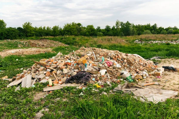Defocus büyük harabeler, Ukrayna enkazı, savaş. Rus saldırısından sonra ev üstüne ev. Doğal yeşil çimen arka planında büyük bir çöp yığını, küresel ısınma. Kirlilik. Soyut arkaplan. Odaklanamıyorum.