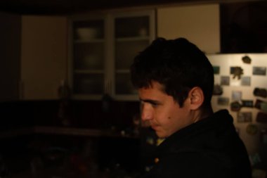 Karanlık mutfaktaki genç adamın defocus portresi. Milenyum karanlık portresi. Akıl sağlığı. Kriz, umutsuzluk, acı. Odaklanamıyorum.