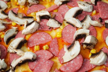 Hamur üzerinde pizza için Defocus yakın çekim malzemeleri. Kırmızı domates sosu, sosis, tatlı mısır. Ev yapımı İtalyan pizzası. Margarita üssü. Ev mutfağı. Üst Manzara. İtalyan mutfağı geçmişi. Odaklanamıyorum.