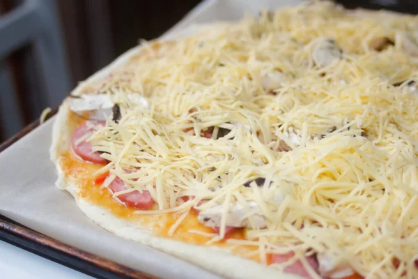 Defocus, taze rendelenmiş mozzarella peynirli tüm pizzayı yakından çek. Defocus hamur üzerinde pizza malzemelerini bulanıklaştırdı. Uzayı kopyala İtalyan mutfağı geçmişi. Arkaplan. Margarita. Odaklanamıyorum.