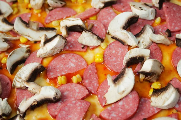 Hamur üzerinde pizza için Defocus yakın çekim malzemeleri. Kırmızı domates sosu, sosis, tatlı mısır. Ev yapımı İtalyan pizzası. Margarita üssü. Ev mutfağı. Üst Manzara. İtalyan mutfağı geçmişi. Odaklanamıyorum.