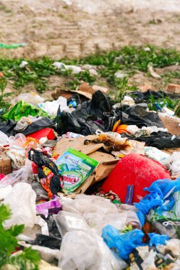 Volodymyr, Ukrayna - 05.06.2021: büyük çöp sahalarını bulanıklaştırdı. Ekoloji kavramı. Doğal yeşil çimen arka planında büyük bir çöp yığını, küresel ısınma. Dikey. Kirlilik. Odaklanamıyorum.