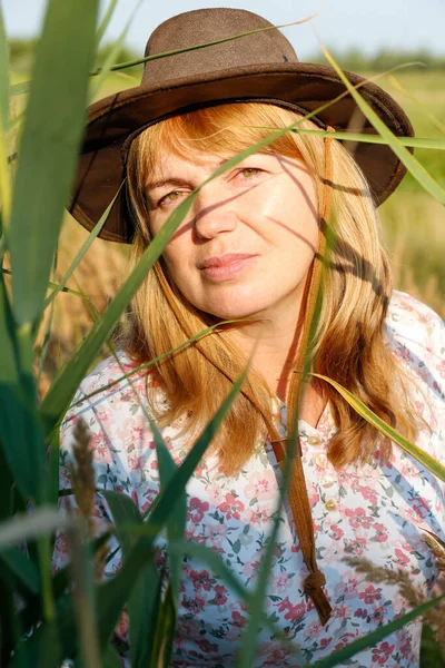 Defocus, sazlığın ve otların yanında güzel sarışın bir kadının portresinin hemen dışında. Sanat gölgeleri ekin. Meadow 'daki kovboy kız. Akıl sağlığı, sessizlik. Kırsal kesimde, sağlıkta. Dikey Odaklanamıyor.