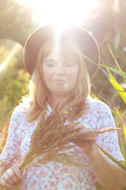 Defocus, doğa arka planında güzel sarışın bir kadının dış portresini yakından çek. Elinde pampa otları tutan bir kadın. Akıl sağlığı, sessizlik. Yaşam tarzı, sağlık, boho. Gün doğumu. Odaklanamıyorum.