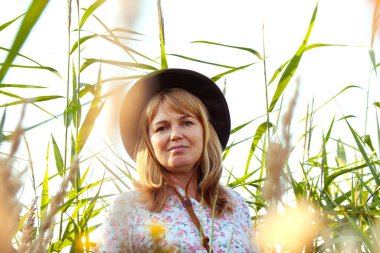 Defocus, doğa arka planında güzel sarışın bir kadının dış portresini yakından çek. Sanat gölgeleri ekin. Meadow 'daki kovboy kız. Akıl sağlığı, sessizlik. Yaşam tarzı, sağlık, denge. Odaklanamıyorum.