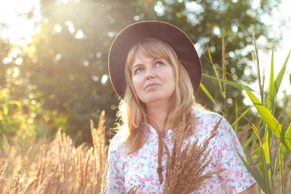 Defocus, doğa arka planında güzel sarışın bir kadının dış portresini yakından çek. Elinde pampa otları tutan bir kadın. Akıl sağlığı, sessizlik. Yaşam tarzı, sağlık, boho. Güneşli. Odaklanamıyorum.