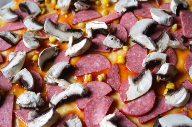 Hamur üzerinde pizza için Defocus yakın çekim malzemeleri. Kırmızı domates sosu, sosis, tatlı mısır. Ev yapımı İtalyan pizzası. Ev mutfağı. Üst Manzara. İtalyan mutfağı geçmişi. Uzayı kopyala Odaklanamıyorum